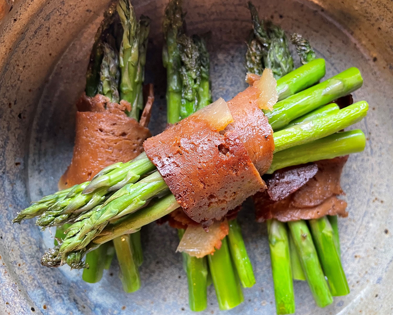 a bundle of asparagus wrapped in vegan bacon