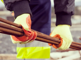 Construction worker handling rebar with eco-friendly cut resistant gloves