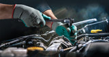 Mechanic working on vehicle engine wearing biodegradable work gloves