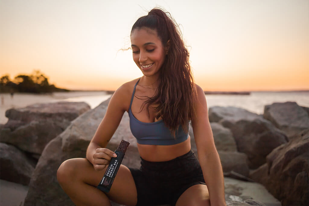 girl eating Tropeaka Protein Energy Bar