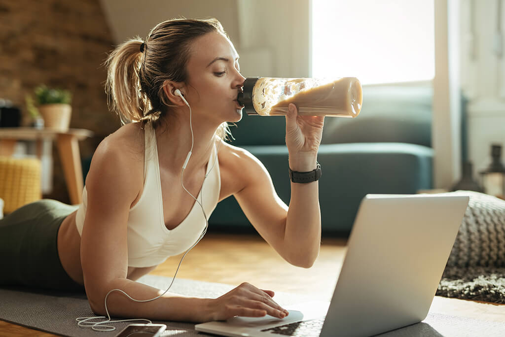 girl drinking a smoothie while working