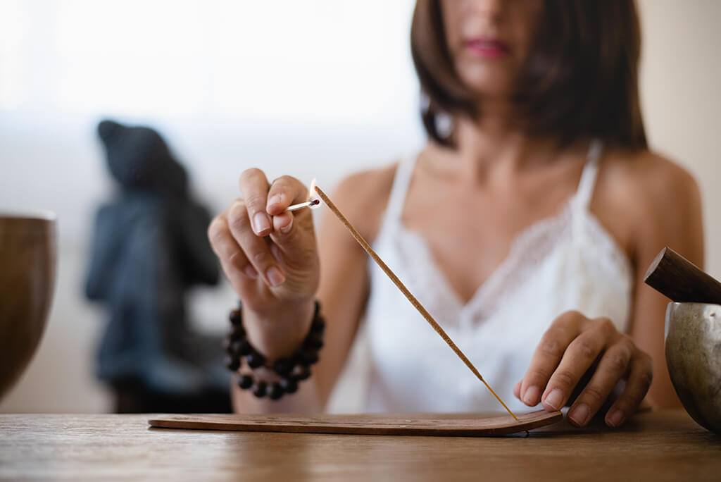 girl lighting an incense