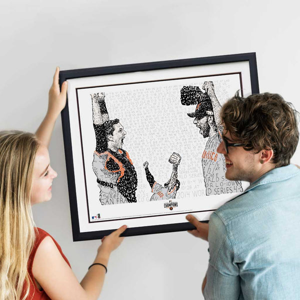 Blonde woman and brown-haired man hang up 2014 Giants World Series framed Art of Words artwork on the wall.