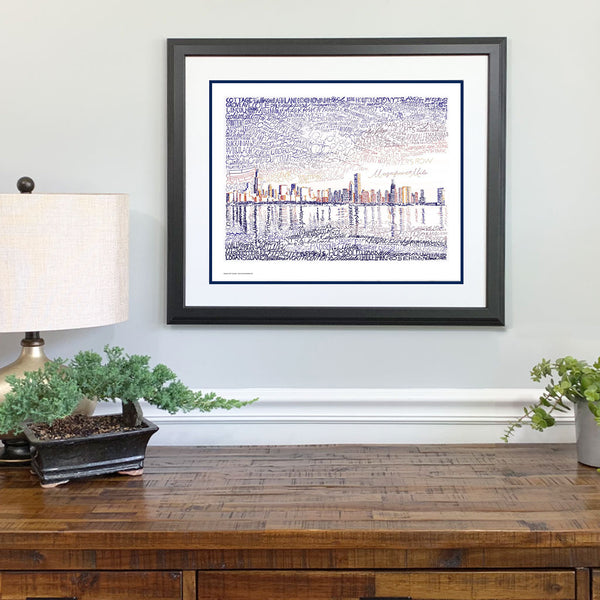 Framed word art view of Chicago skyline, handwritten with names of streets and neighborhoods, hangs on wall.