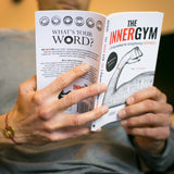 A person reading The Inner Gym book while wearing their MyIntent bracelet