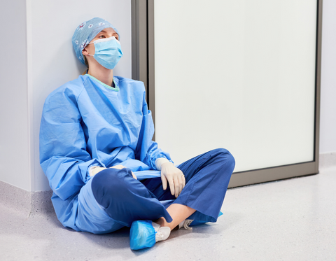 Stressed out doctor sitting on the floor