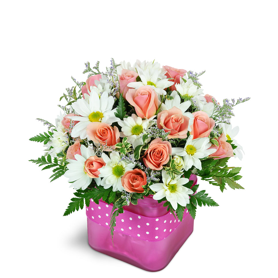 Bubble Gum Bliss premium flower arrangement. A fun mix of pink spray roses, white daisies, and fresh greenery are arranged in a glass vase.