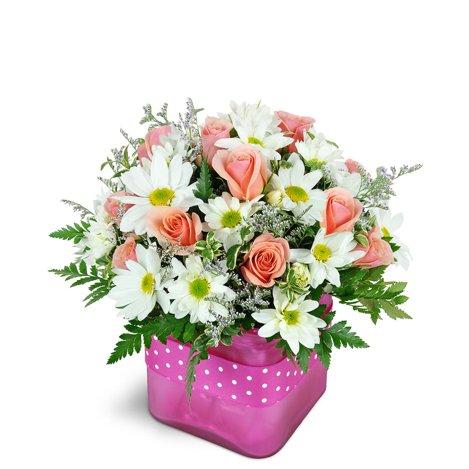 Bubble Gum Bliss deluxe flower arrangement. A fun mix of pink spray roses, white daisies, and fresh greenery are arranged in a glass vase.