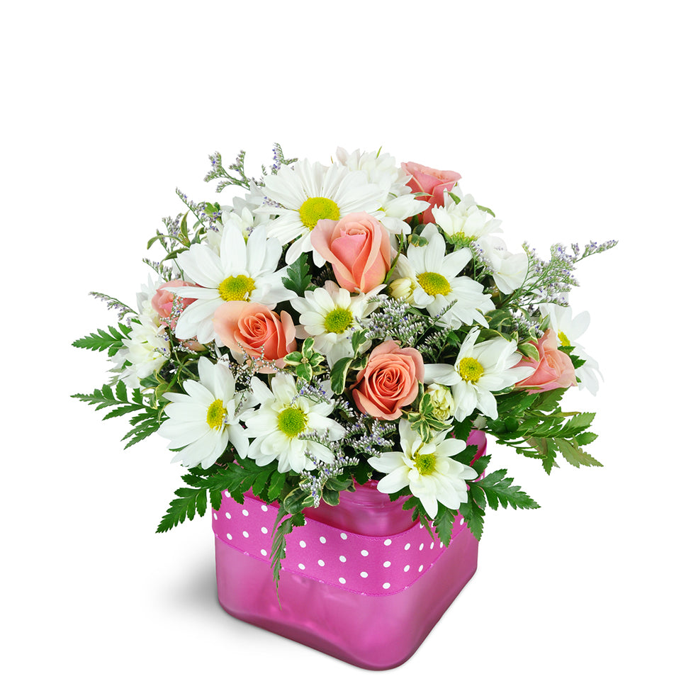 Bubble Gum Bliss standard flower arrangement. A fun mix of pink spray roses, white daisies, and fresh greenery are arranged in a glass vase.