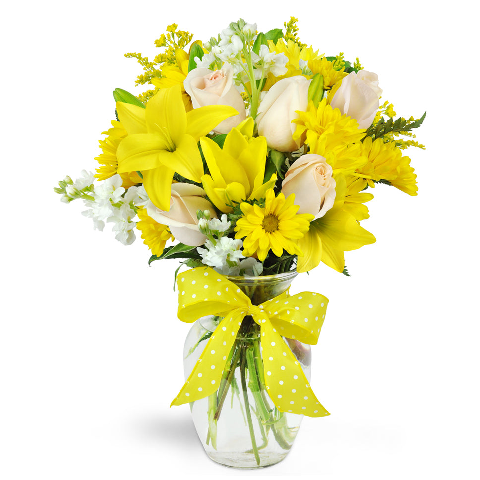 Smile a Mile Daisy Vase™ - Premium. Yellow lilies and daisies are arranged with cream roses and topped off with a bright ribbon.