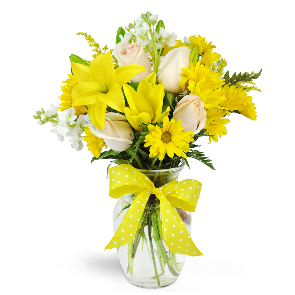 Smile a Mile Daisy Vase™ - Deluxe. Yellow lilies and daisies are arranged with cream roses and topped off with a bright ribbon.