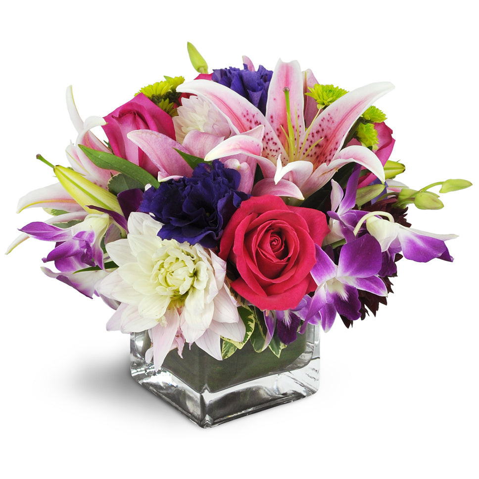 She's a Jewel™. Abundant roses, lilies, dahlias, orchids, and more are arranged in a modern glass vase.