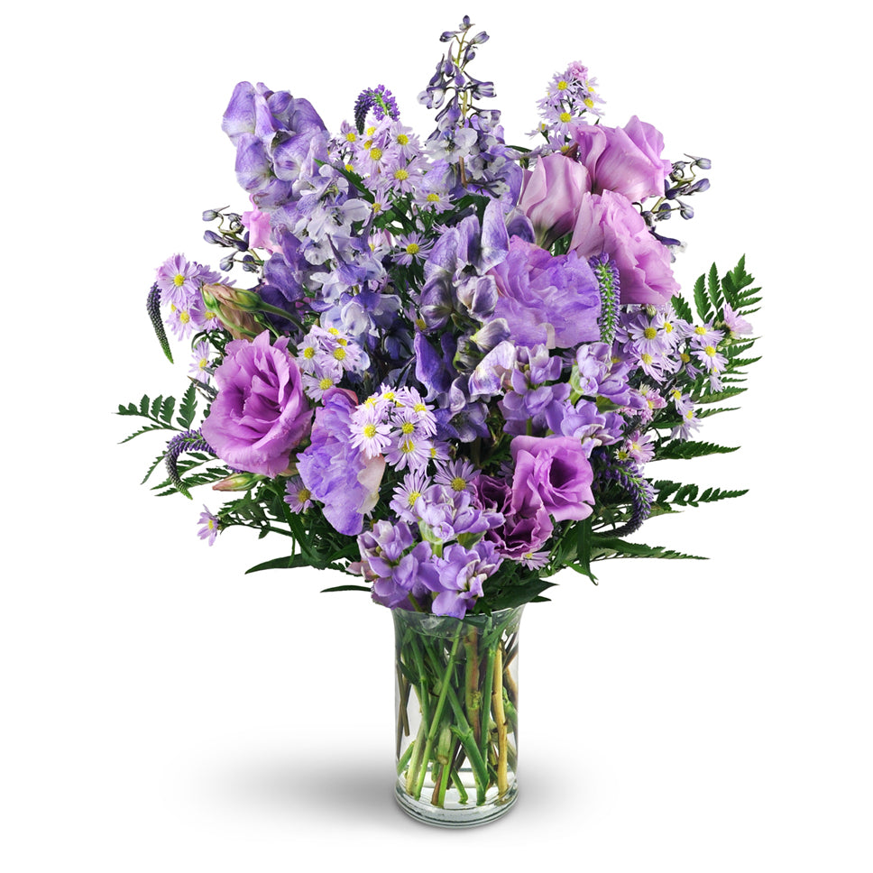 Purple Passion - Deluxe. Monk's hood, delphinium, veronica, purple lisianthus, Monte Cassino asters, and more are delightfully arranged in a classic glass vase.