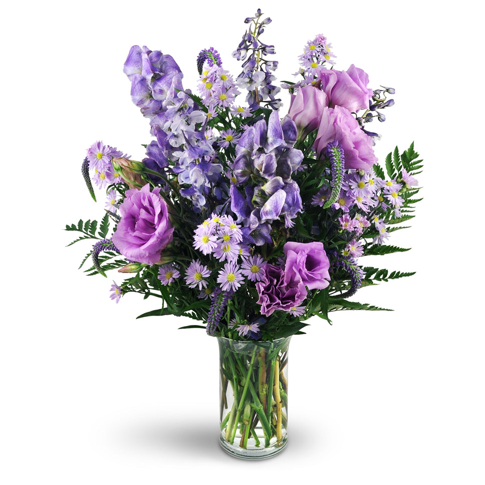 Purple Passion - Standard. Monk's hood, delphinium, veronica, purple lisianthus, Monte Cassino asters, and more are delightfully arranged in a classic glass vase.