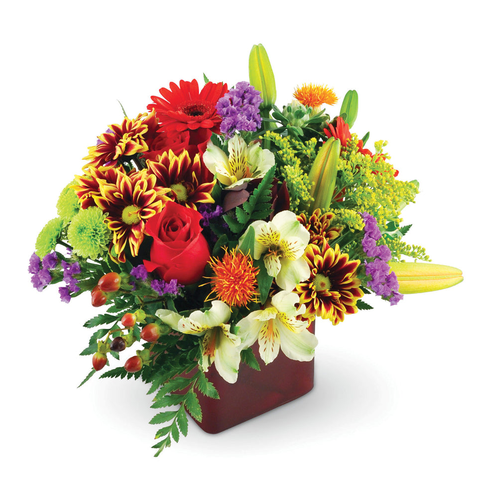 Good Old Summertime™. Mini Gerbera daisies, Asiatic lilies, roses, chrysanthemums, and more are arranged in a glass vase.