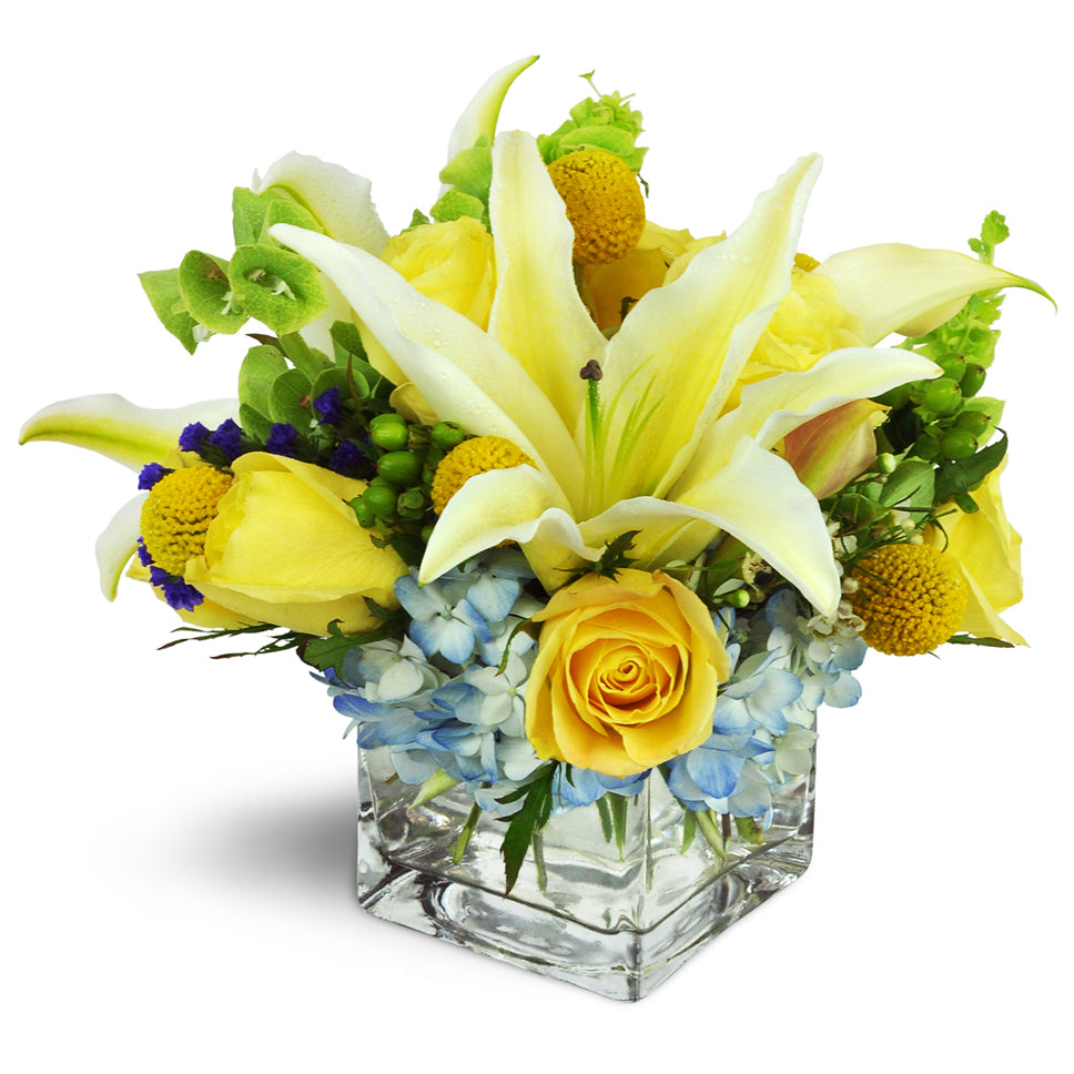 Sweet Seaside™. A beachy beauty featuring lilies, roses, hydrangea, and more arranged in a modern glass cube.