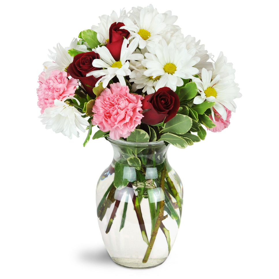 I'm Smitten™. Red roses, pink carnations, and charming white daisies are artfully arranged in a classic glass vase.