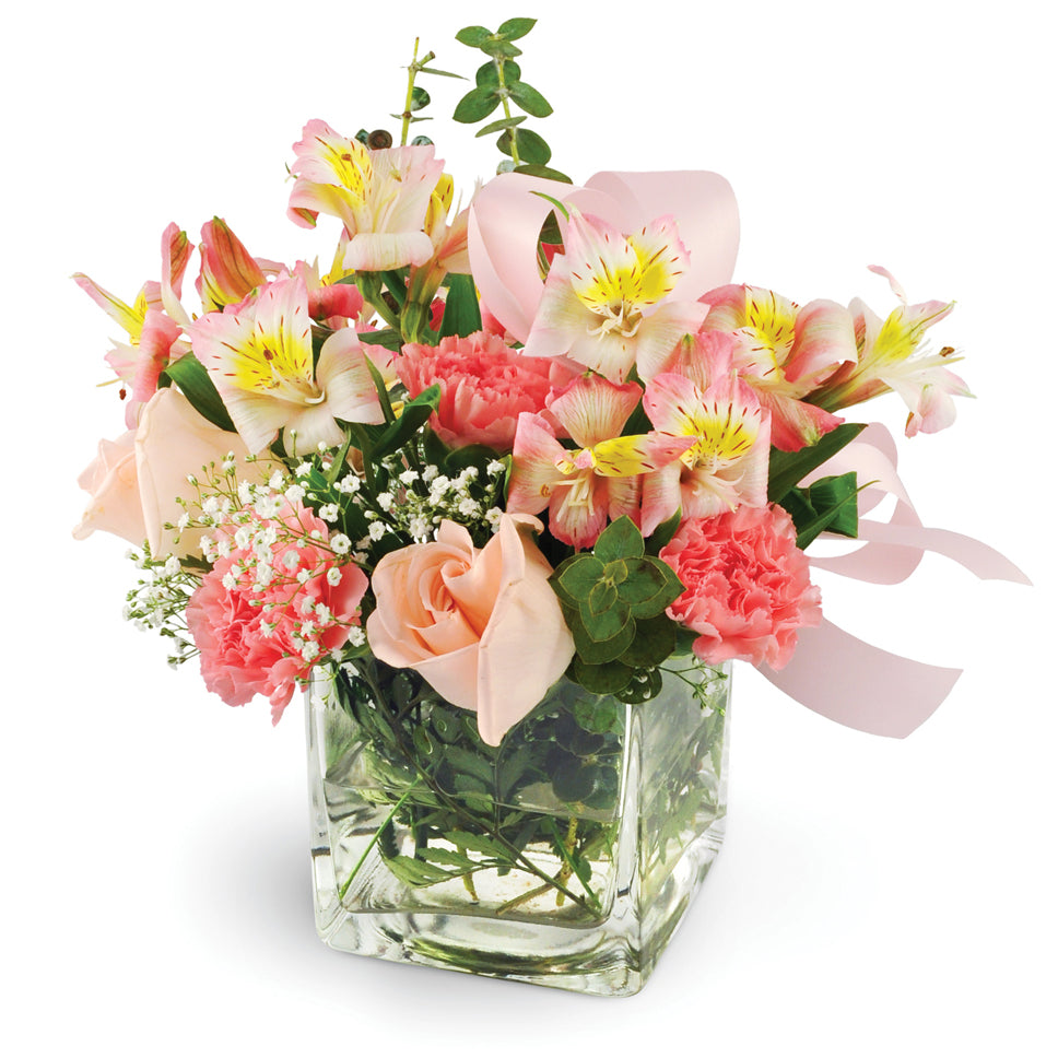 She's So Darling. Pink roses, pink carnations, pink alstroemeria, eucalyptus, and baby's breath are beautifully placed in a glass vase and tied with a pink ribbon.