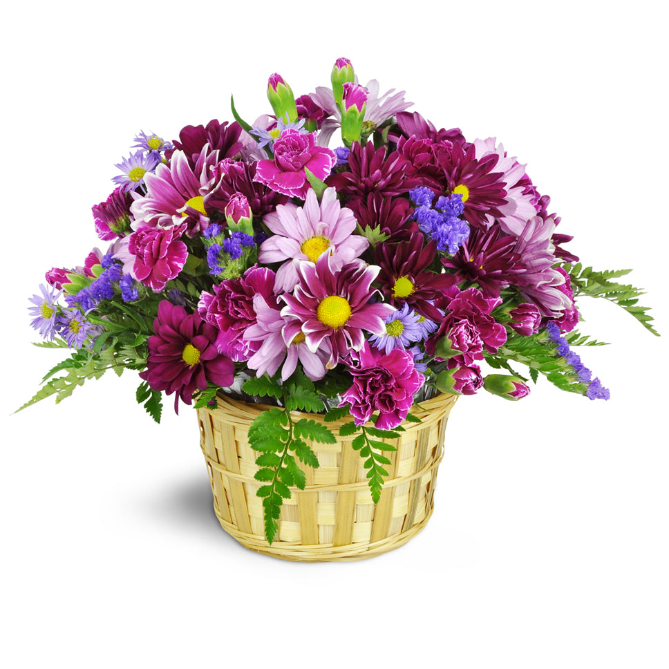 Amethyst Skies Basket standard flower arrangement. Daisies, carnations, asters, miniature carnations, and more—are beautifully arranged in shades of lavender and deep plum.