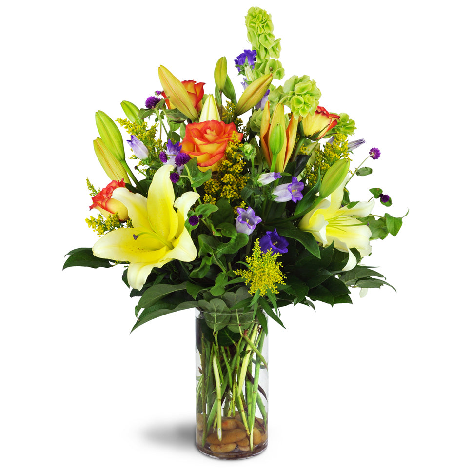 Garden Splendor Bouquet™. Surprise them with lilies, roses, and more arranged in a glass vase and accented with river rocks.