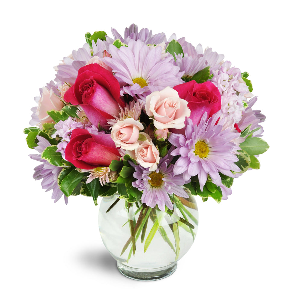 Sweet Surprise™ - Deluxe. Hot pink roses stand out among light pink and lavender daisies, spray roses, and more.