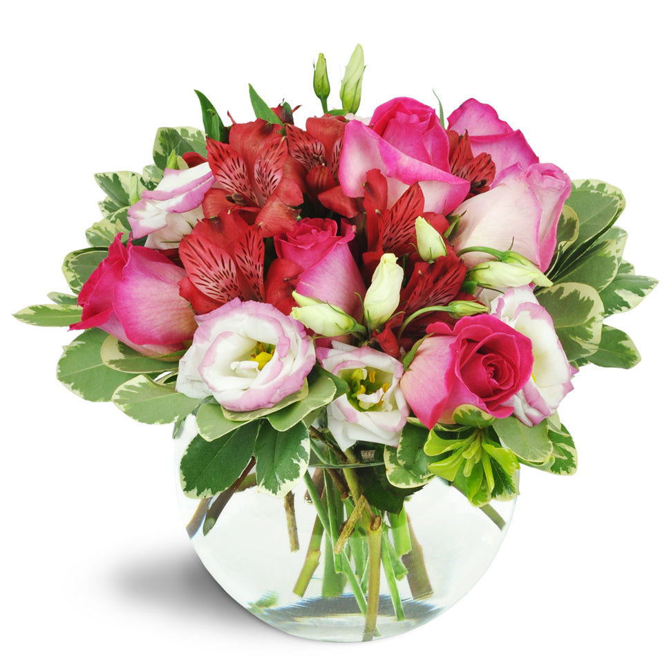 Cupid's Arrow™ - Standard. Pink roses, creamy lisianthus, lush red alstroemeria, and more burst from a charming bubble bowl vase.