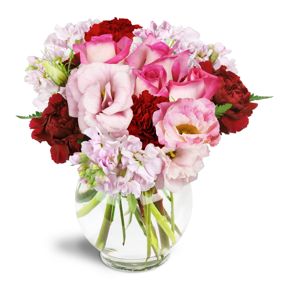 Joyful Heart™ - Deluxe. Bring joy to all with pink roses, lisianthus, stock, and red carnations.