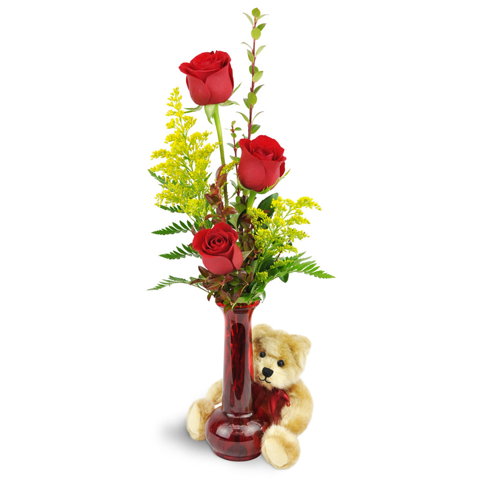 Rose Trio™ with Plush Bear. Three red roses are arranged with greenery and encircled by a beige plush bear.