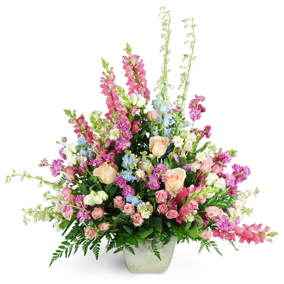 Adoring tribute flower arrangement. Overflowing with roses, spray roses, snapdragons, delphinium, and more.