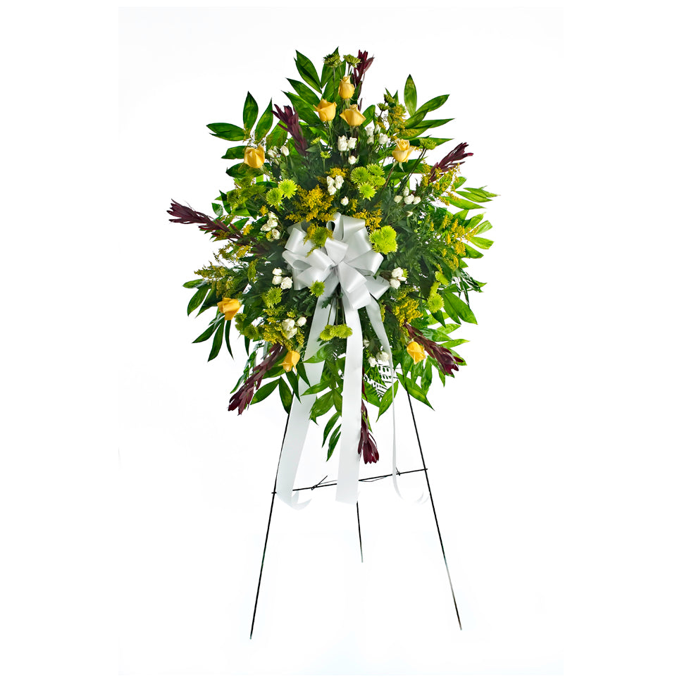 Warm Thoughts. Yellow roses, white spray roses, green poms, and more are beautifully arranged for display at the funeral home or church.