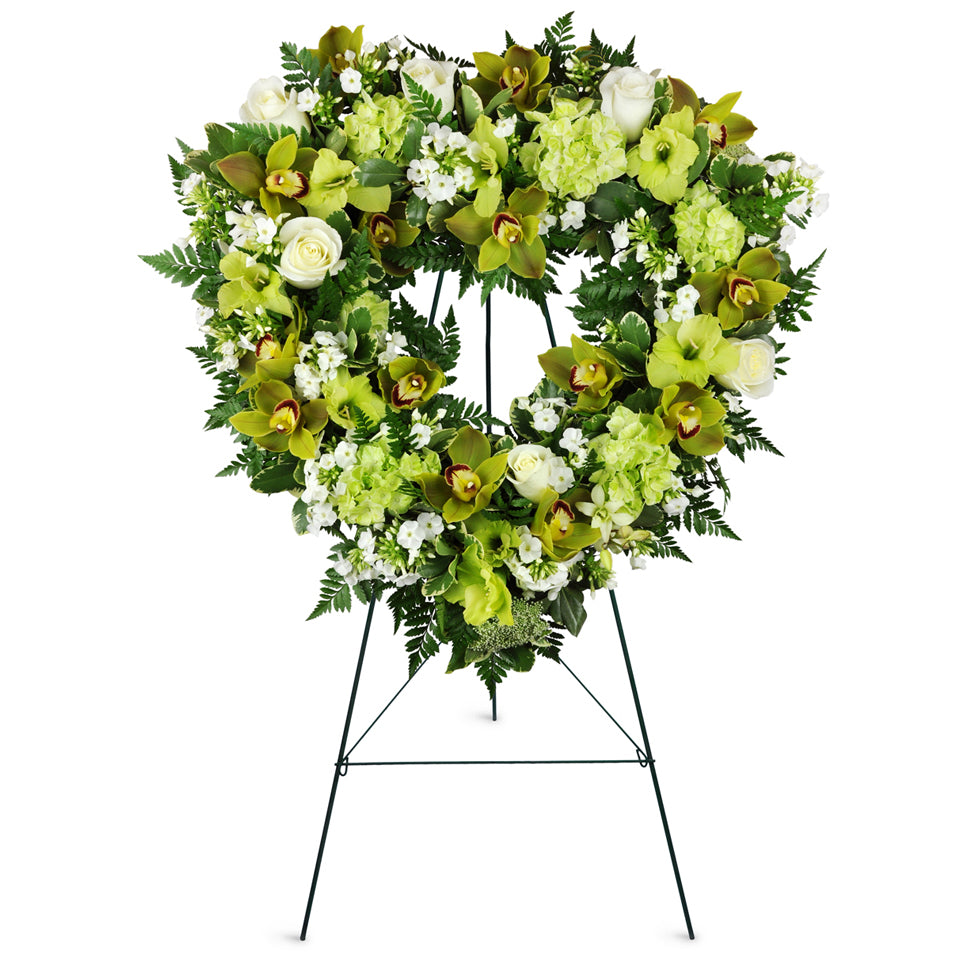 Open Heart Orchid Spray™. Cymbidium orchids, Dendrobium orchids, roses, gladiolus, and more are arranged for display at the funeral home or service.