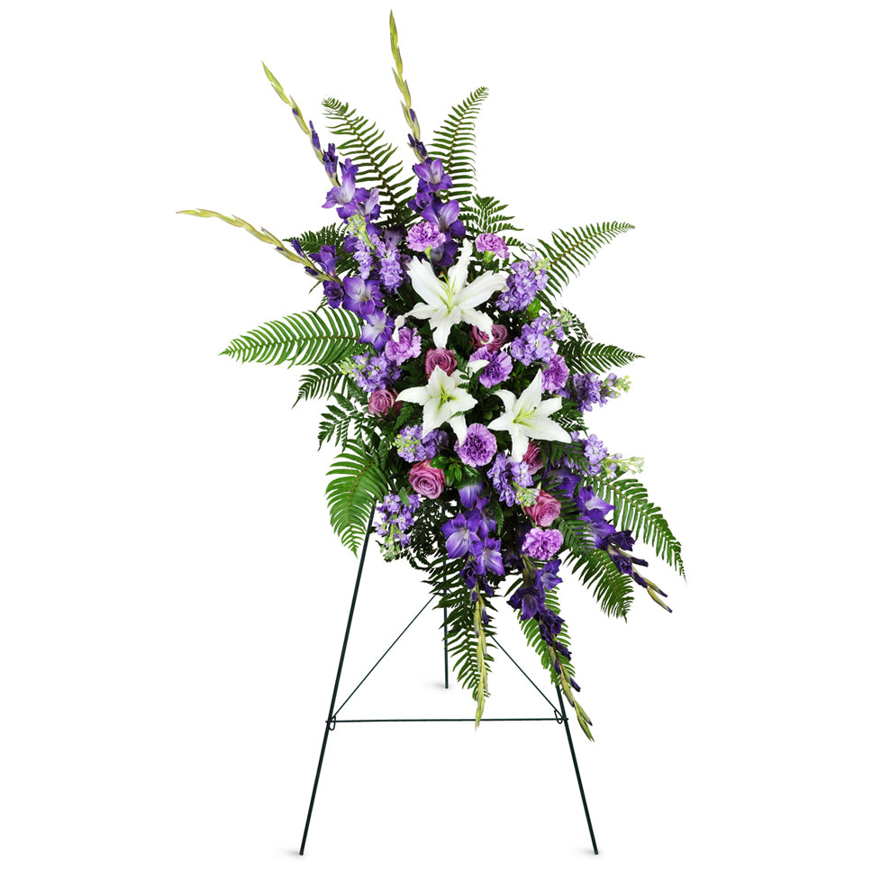 Lavender Memories Spray™. Ease feelings of sorrow with white Asiatic lilies, purple gladiolus, lavender roses, purple carnations, stock, and sword fern greenery plumes arranged in a traditional funeral spray.