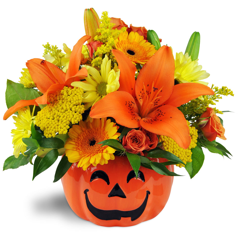 Jack O'Lovely Vase™. Lovely lilies, mini Gerbera daisies, spray roses, and daisies are arranged in a cute orange jack o’lantern-shaped ceramic vase.