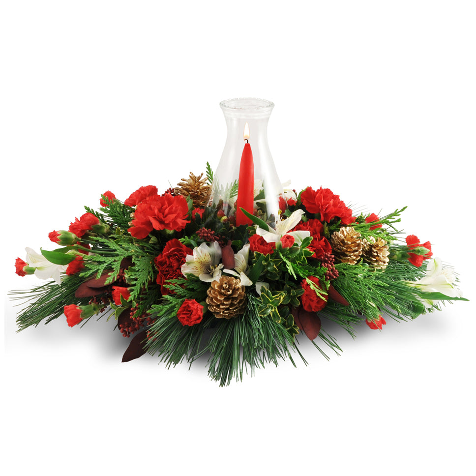 Warming Glow - Standard. Carnations, alstroemeria, pinecones, cedar, and more are topped with a taper candle in a delicate hurricane glass.