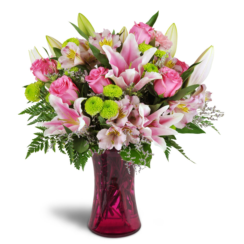 Perfectly Pink™ - Deluxe. Your arrangement will include bright pink roses, carnations, and alstroemeria, plus lime green poms for added charm.