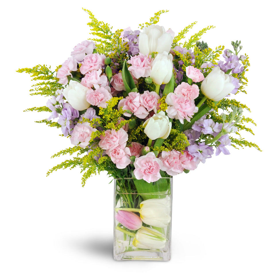 Pretty in Pinks™. Wow them with white tulips, ruffled pink mini carnations, and lavender stock arranged in a glass vase.