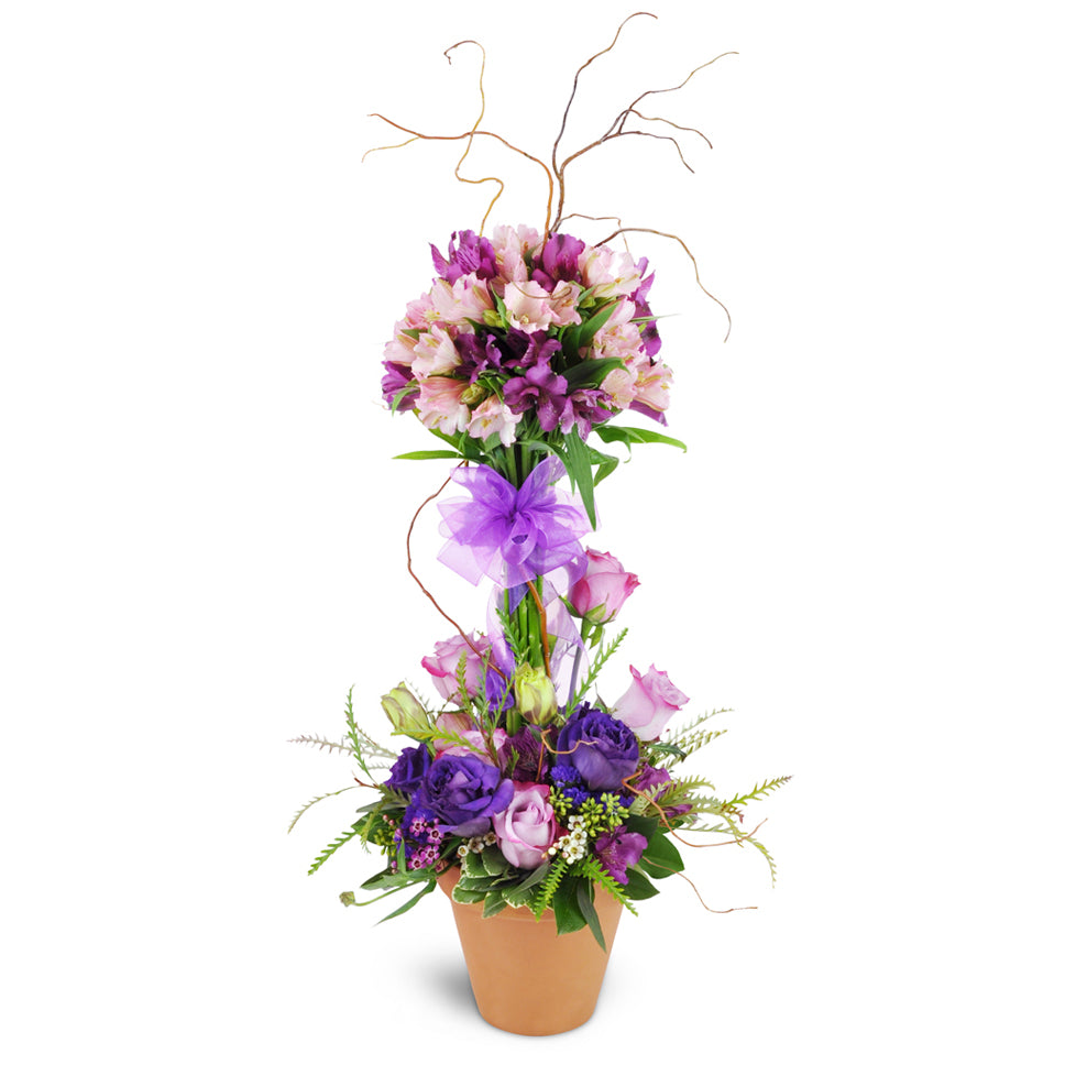 Elegant Embrace™ Topiary. Roses, lisianthus, and more are artfully arranged in a stunning design, encircling a topiary-style tower of alstroemeria blooms.