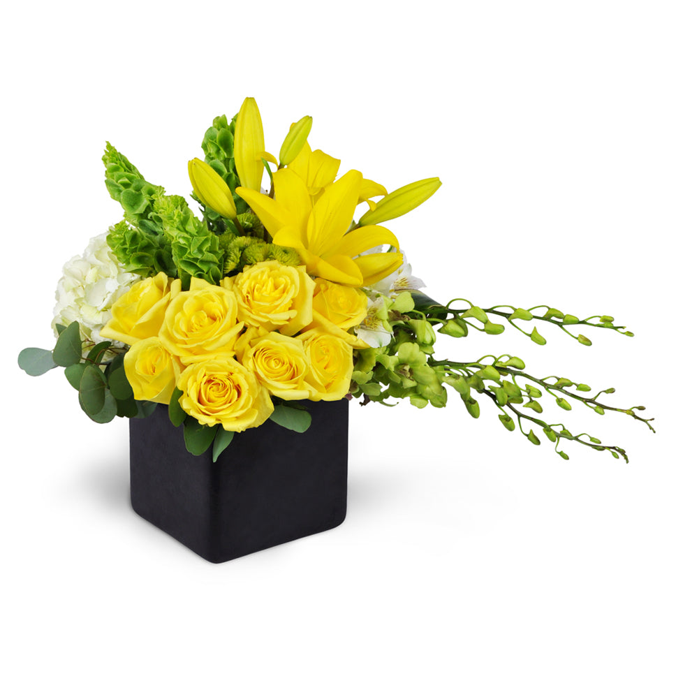 Sensational Smiles™ - Deluxe. Yellow roses, Dendrobium orchids, and more are arranged in a ceramic container.
