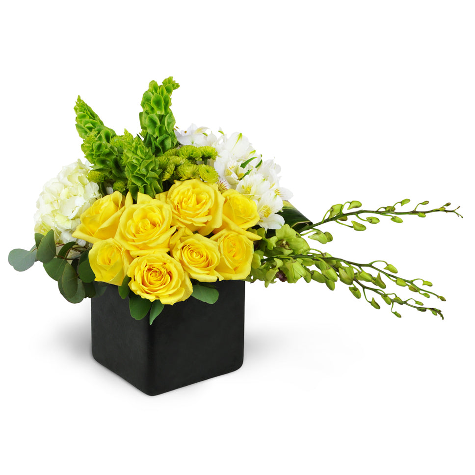 Sensational Smiles™ - Standard. Yellow roses, Dendrobium orchids, and more are arranged in a ceramic container.