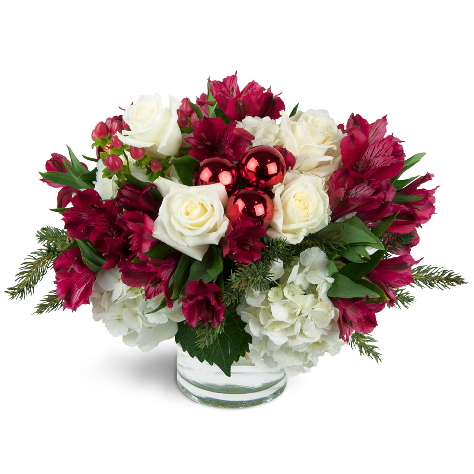 Very Merry Bouquet™ - Premium. Festive red and white blooms are arranged with holiday greens. Upgrade to Deluxe or Premium to add lovely white roses.