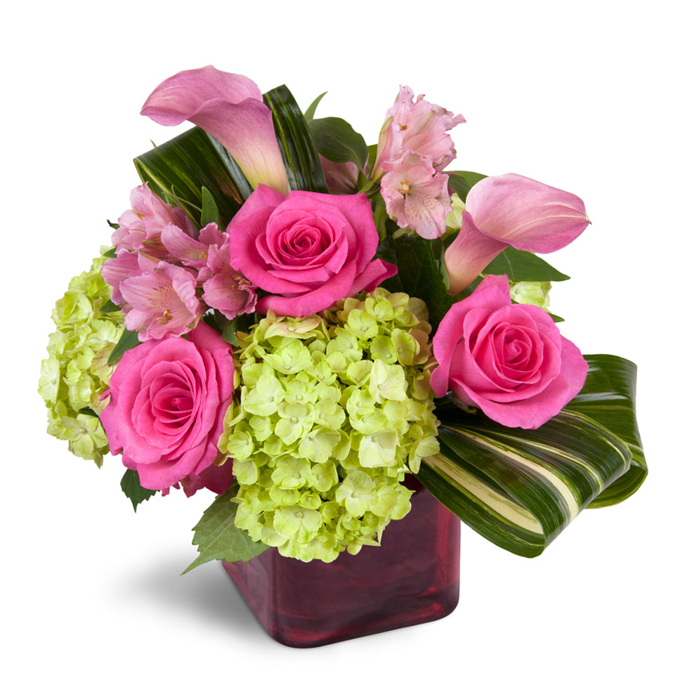 Peek of Chic™ - Deluxe. Hot-pink roses, green hydrangea, and pink Peruvian lilies are accented with fresh aspidistra.