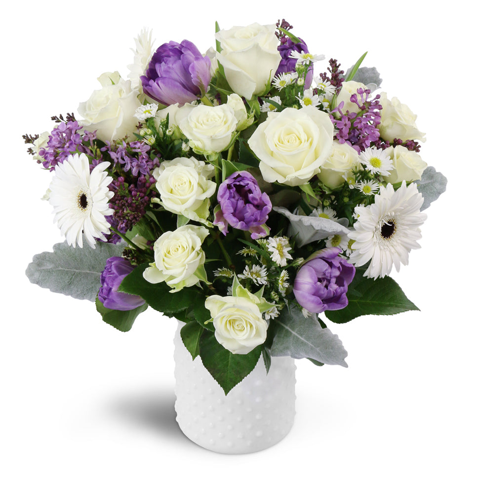 Oasis in Bloom™ - Deluxe. Featuring white spray roses, purple tulips, and more.