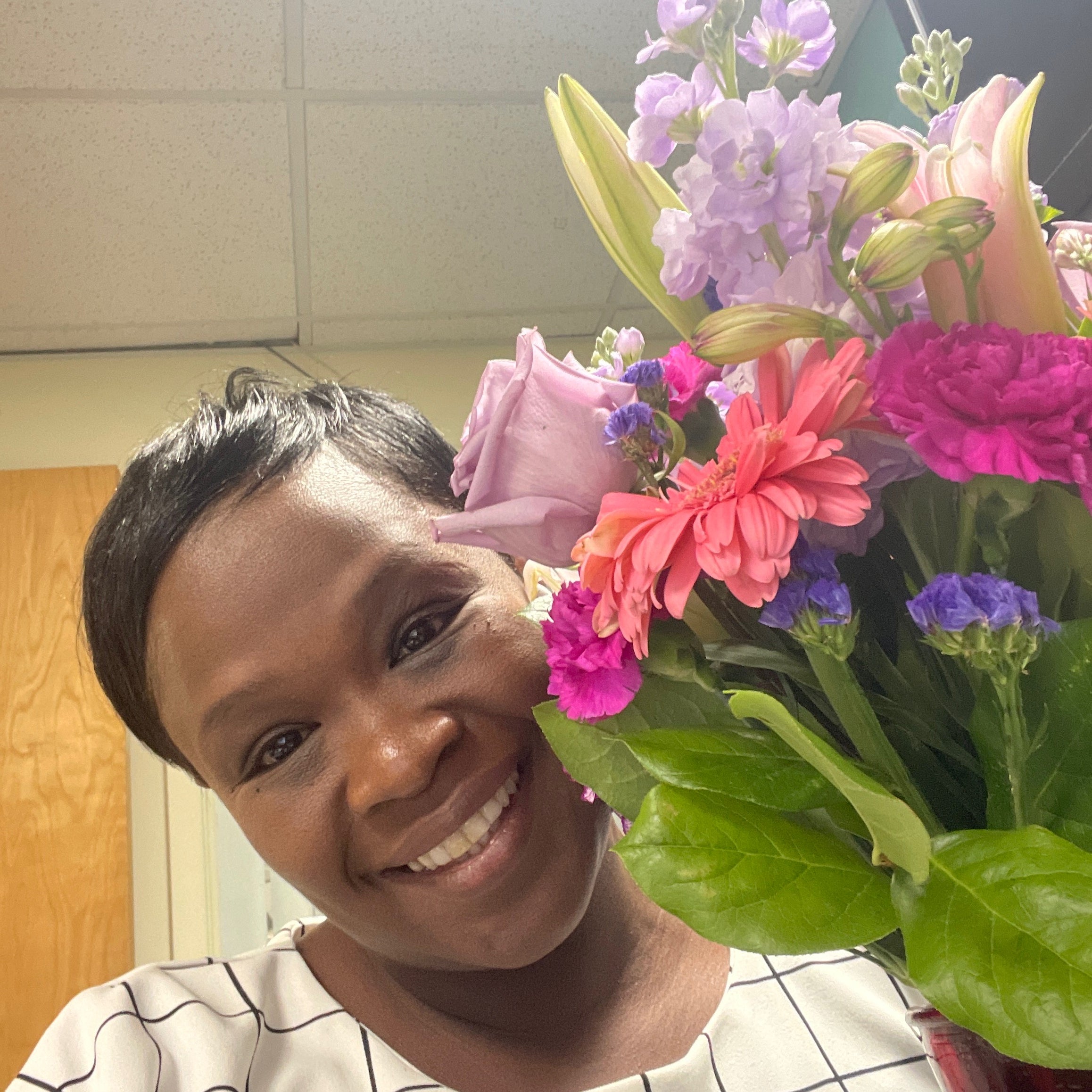A heartfelt thanks for Bright Medley. Smiling woman next to her flower arrangement.