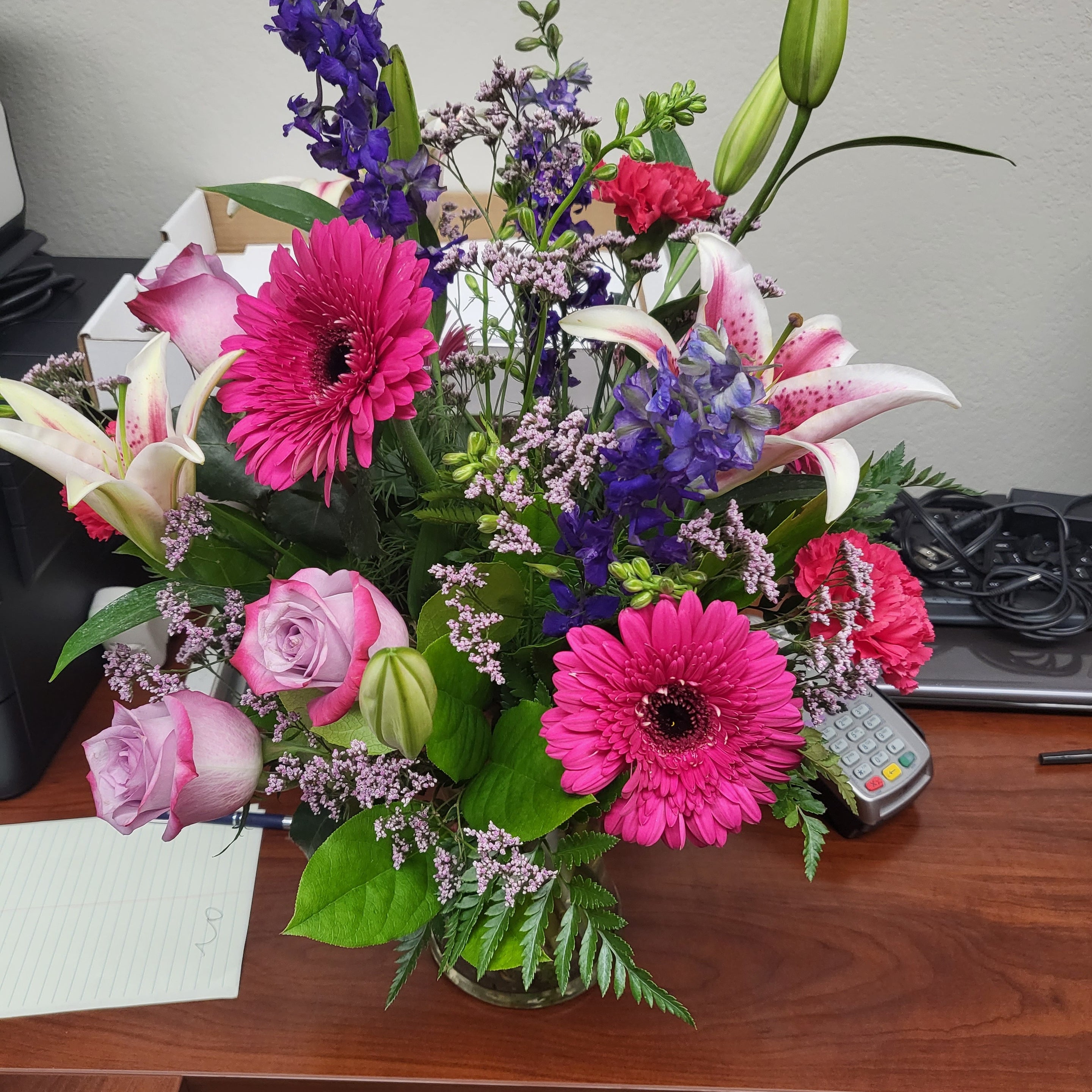 Recipient-submitted photo of Bright Medley flower arrangement on a desk.