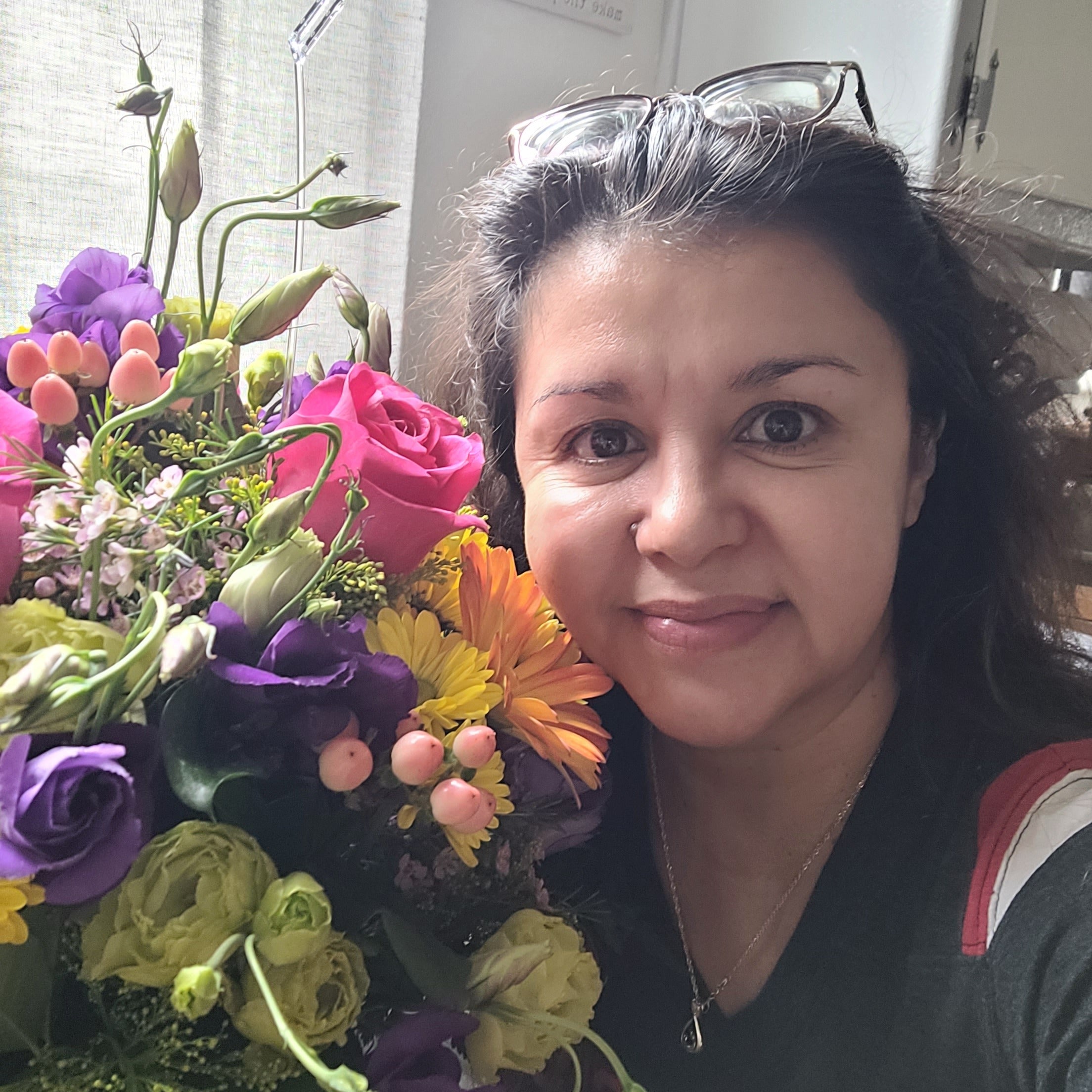 A heartfelt thanks for Birthday Blast flowers. Woman smiling with her gorgeous and full flower arrangement.