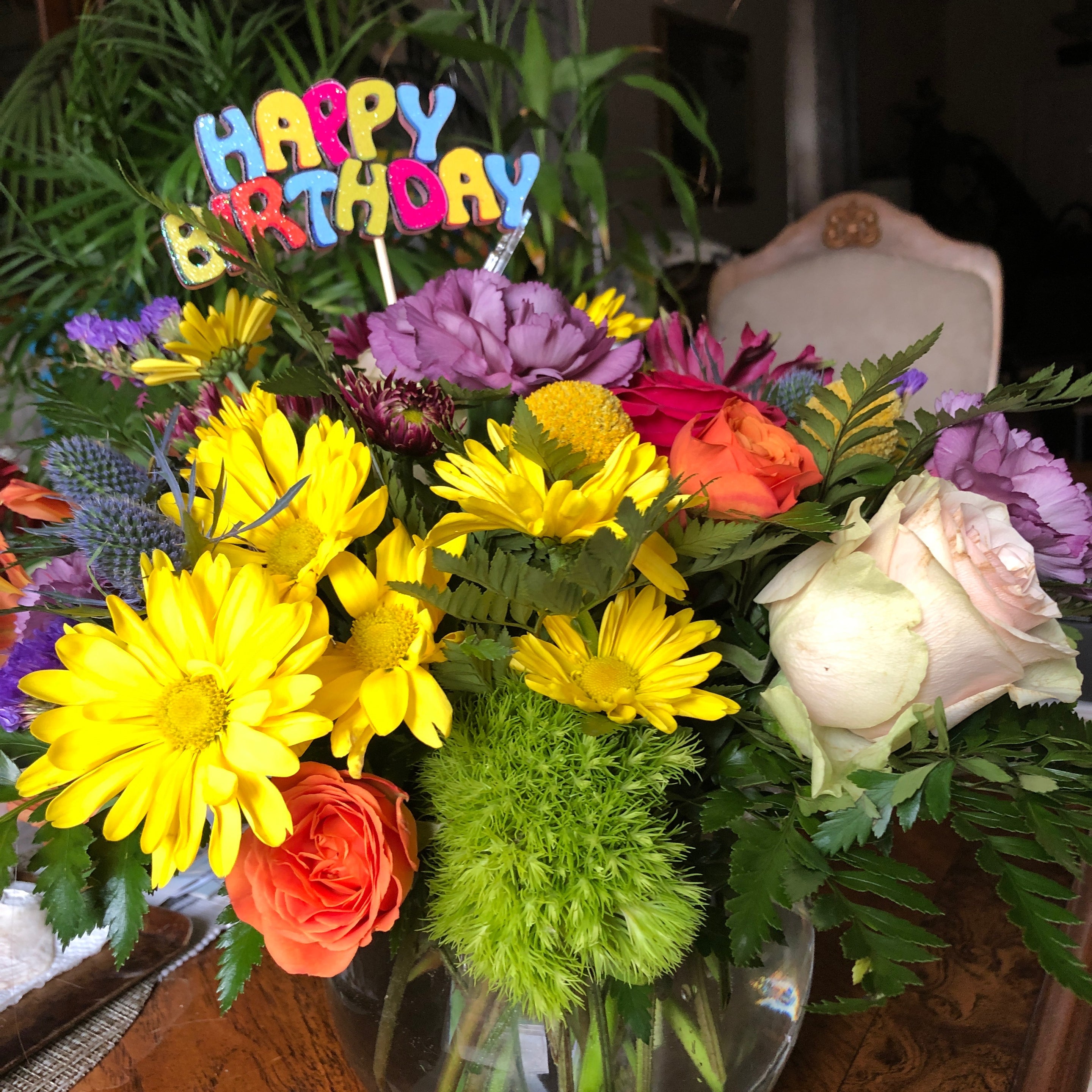 Recipient-submitted photo of Birthday Blast. Flower arrangement on table with a "Happy Birthday" decoration.