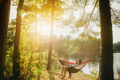 Couple sitting on hammock in woods