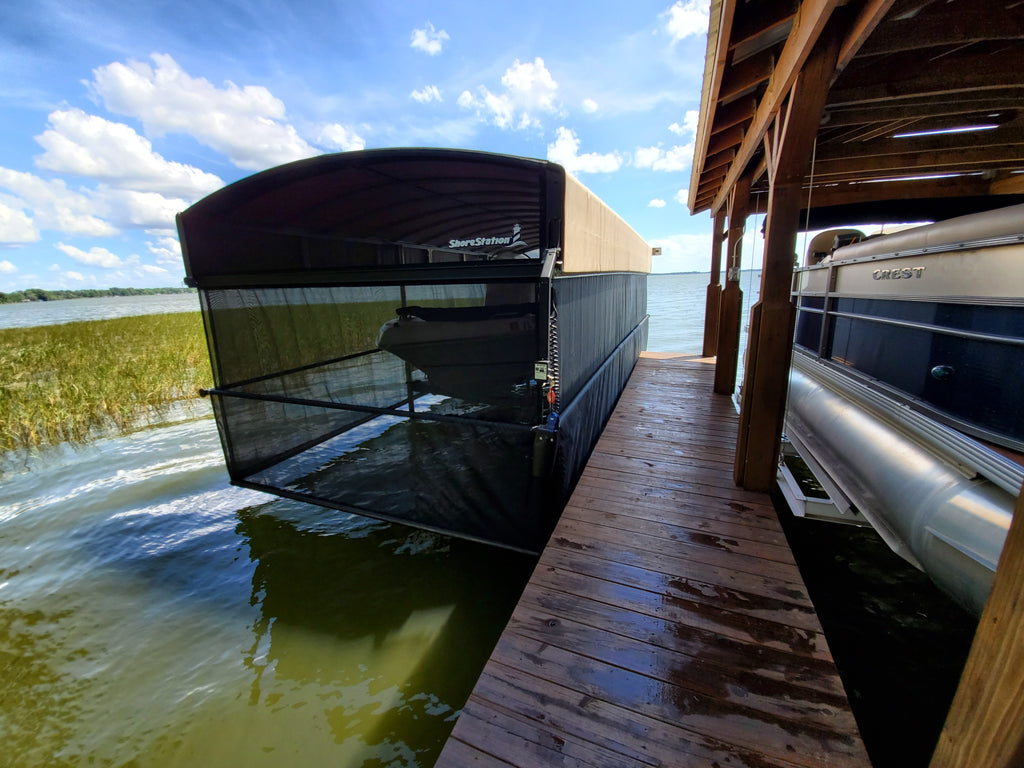 ShoreStation free-standing boat lift alongside a wooden dock with revolution canopy and power curtain add-on