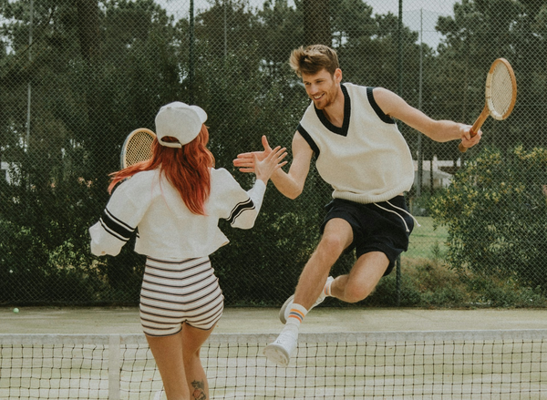 man and woman play tennis