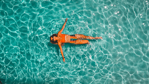 woman wearing sunglasses floating in a pool